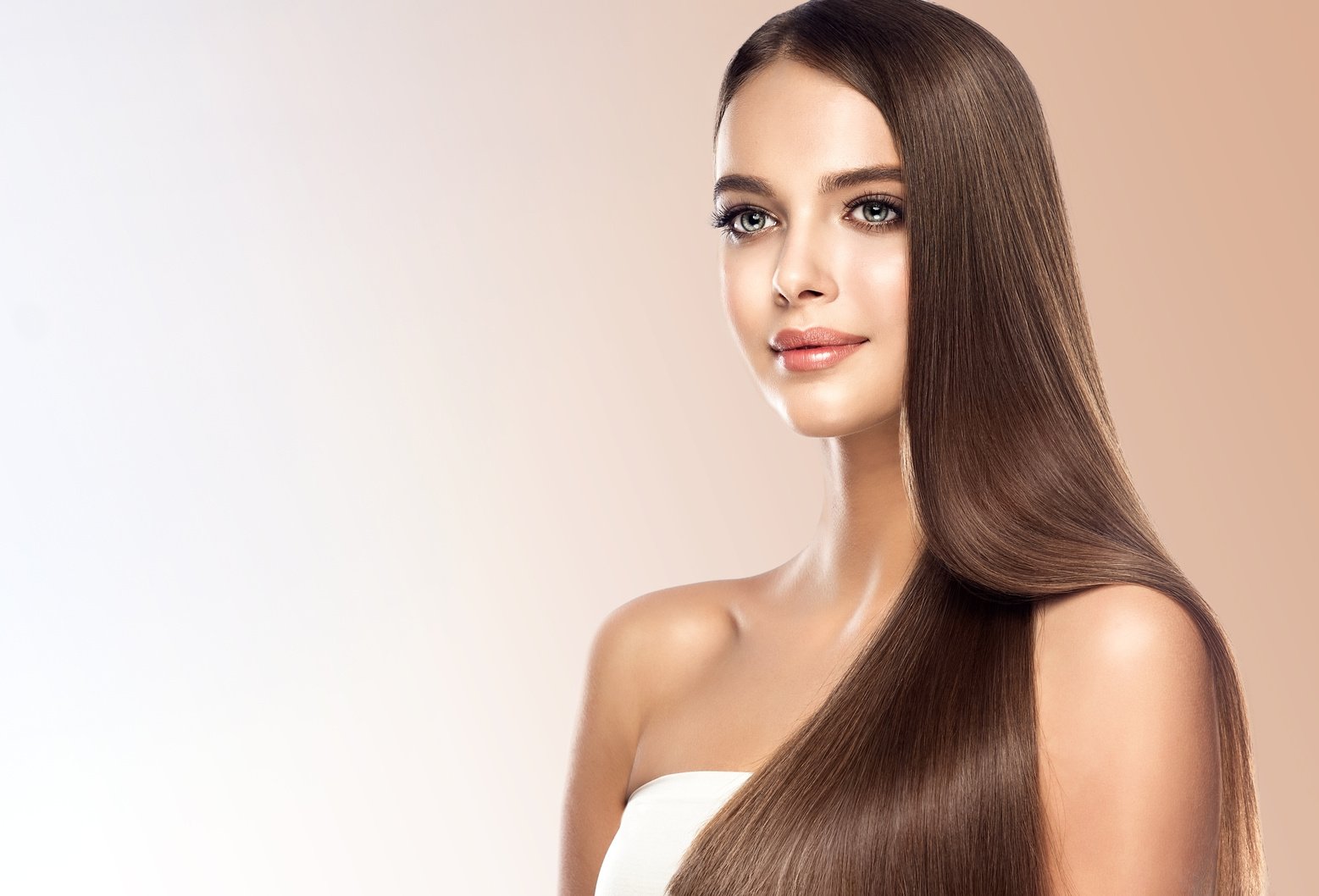 Young, brown haired beautiful model with long,  straight, well groomed hair. Hair care and hairdressing art.